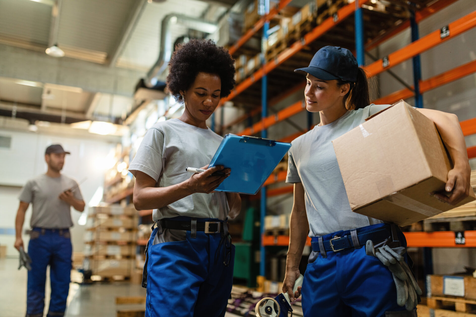Two warehouse workers reviewing a delivery schedule
